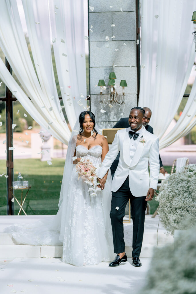 The newlyweds walk back down the aisle through falling confetti