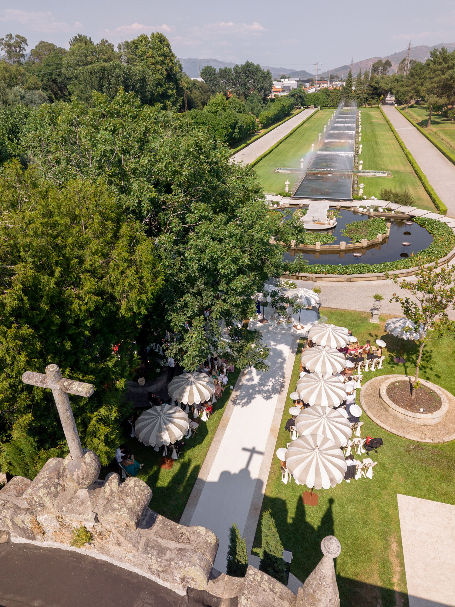 Aerial view of the formal gardens of Solar da Levada, with a symmetrical pond and white parasols set for the ceremony