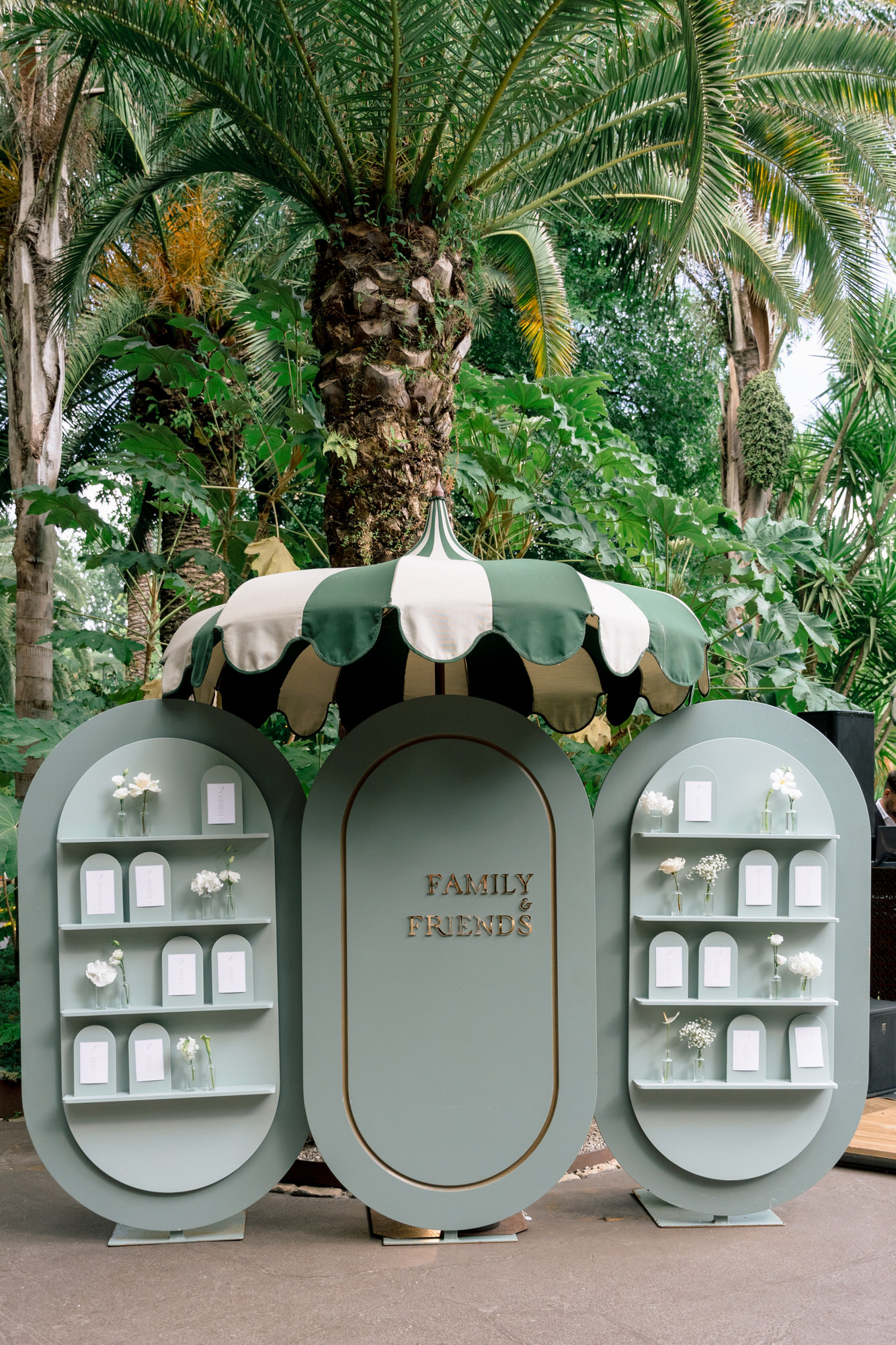 A pale green seating display with a floral top set among palm trees