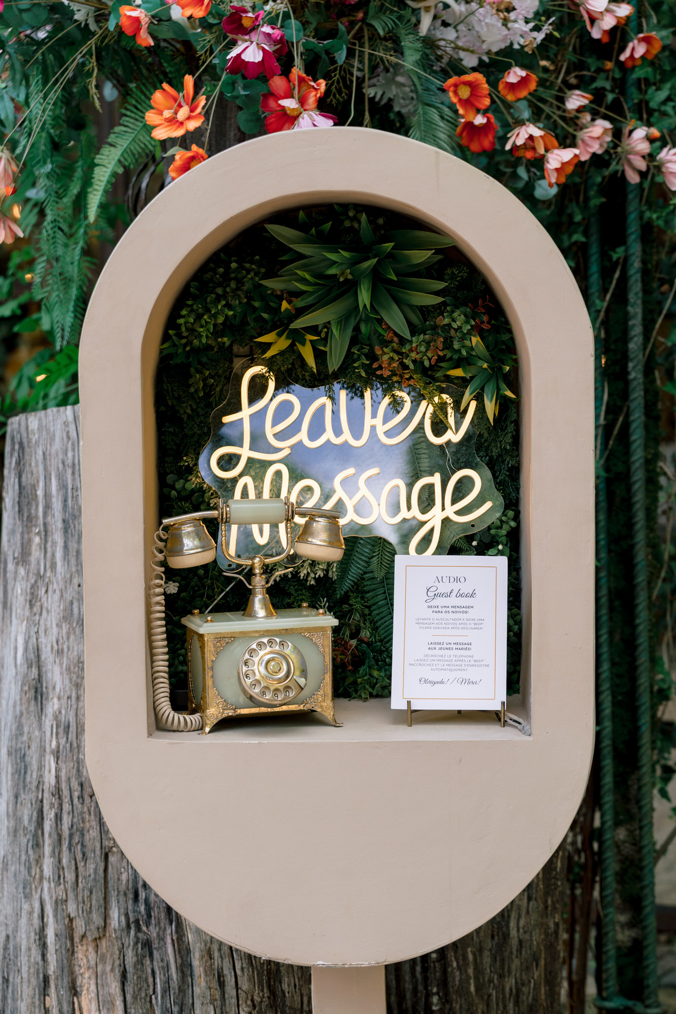 A “leave a message” guestbook sign in an arched frame, decorated with flowers