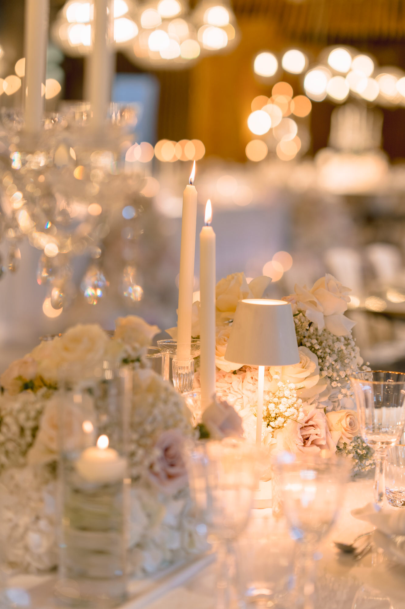 Candlelight, crystal glasses and soft bokeh on the wedding table