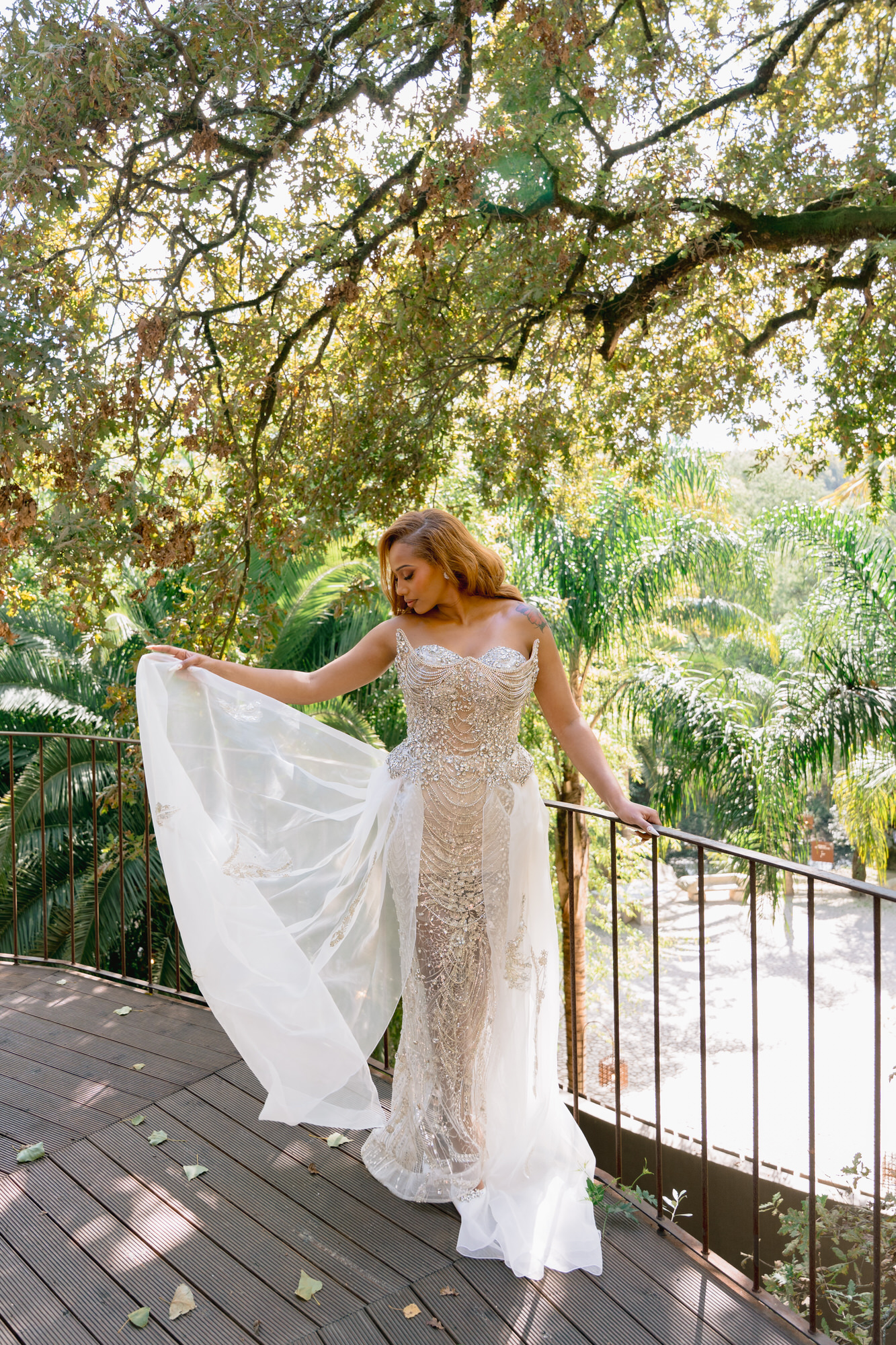The bride lifting her train as she walks along the boardwalk in the woods